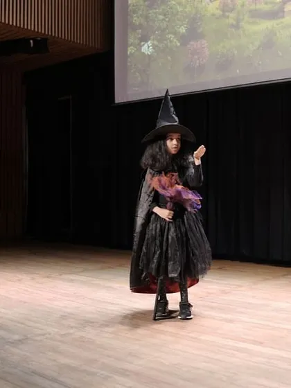 A solo moment for the Wicked Witch, commanding the stage with a strong posture and expression. We encourage every child to find the power in their character, no matter the role.