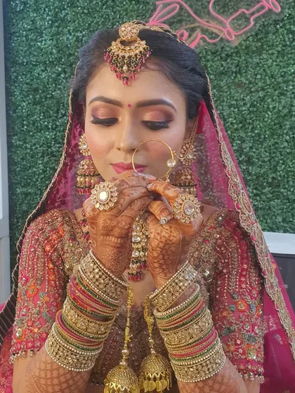 A beautiful candid moment of the bride admiring her look. The makeup is designed to look stunning from every angle, with a focus on glowing skin and expressive eyes.