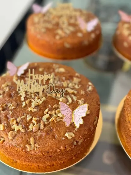 Simple and elegant walnut cakes for Mother's Day, topped with a "Happy Mother's Day" sign and delicate butterflies.
