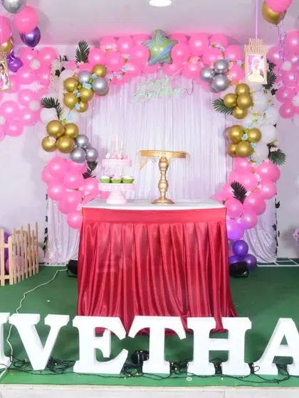 The central cake table setup for the Minnie Mouse-inspired party, framed by a balloon arch with metallic gold and silver accents.
