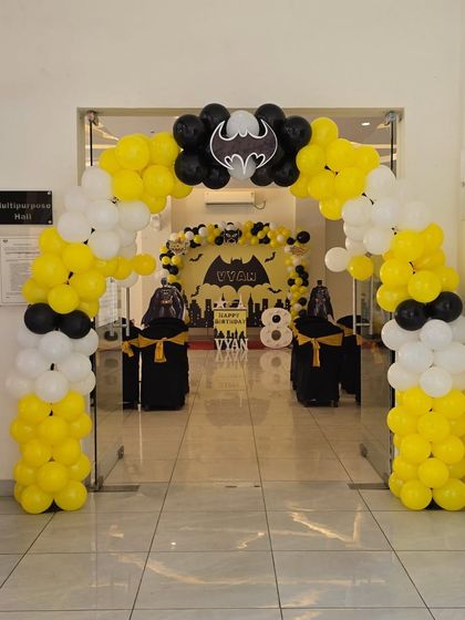 A view from the entrance of the Batman party, showing the balloon arch and the main stage in the background.