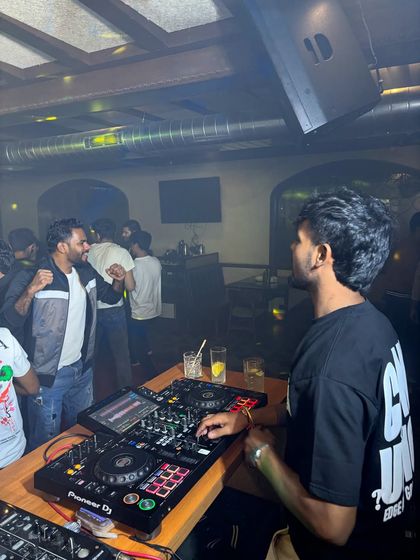 A candid moment at the DJ console, preparing the next track while the party rages on.