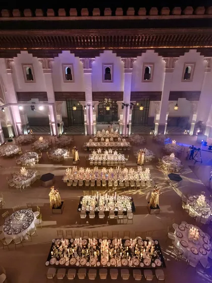 A reception dinner fit for royalty. We designed this palatial ivory-and-gold sit-down dinner in Marrakech to be a grand toast to the newlyweds. The architectural beauty of the venue was amplified by our lighting and table settings, creating an atmosphere of pure elegance.