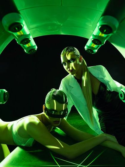 This powerful image visualizes the science of the Emerald Laser. A client undergoes the treatment, protected by safety goggles, while the green lasers work to emulsify fat cells beneath the skin, all under expert supervision.