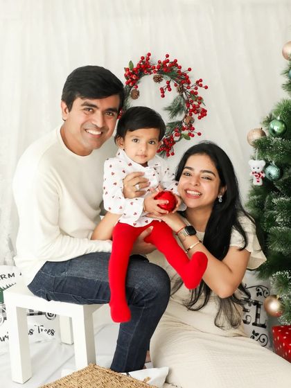 A beautiful family Christmas photo. Coordinated outfits and a classic holiday backdrop make for a perfect portrait to share with loved ones.