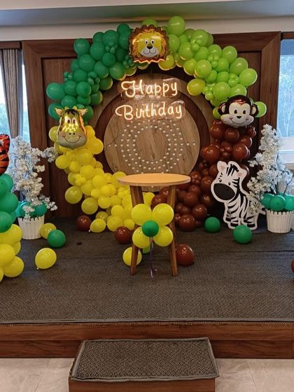 A full stage view of the jungle theme, showing the animal balloon columns and the central arch.