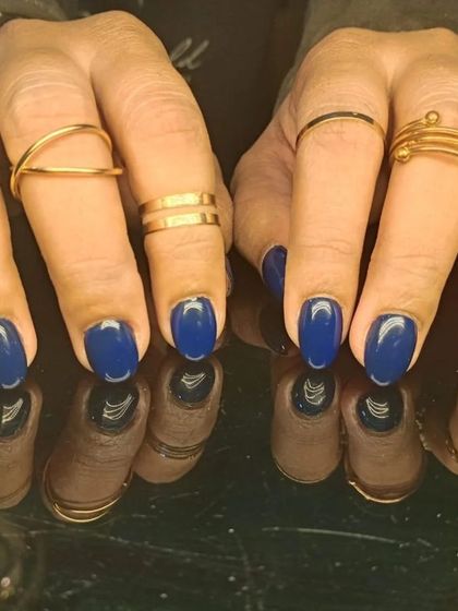 A full set of the chic and sophisticated royal blue nails, styled with gold rings.