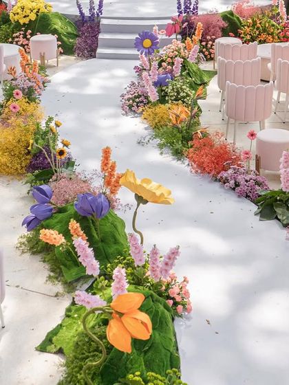An overhead view of the colorful aisle, showing the arrangement of the scalloped pink chairs for guests.