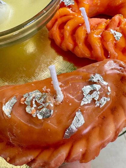Say hello to my gujiya candle. This soy wax creation is glazed and detailed to look so real you'll be tempted to take a bite. It's a unique piece for any festive platter.