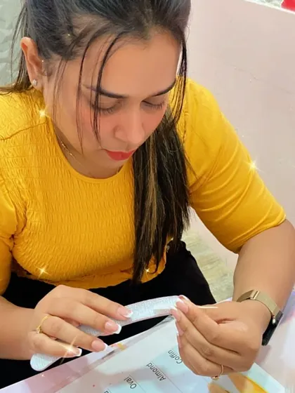 A student practices filing and shaping a French tip, a fundamental skill for this popular nail style.