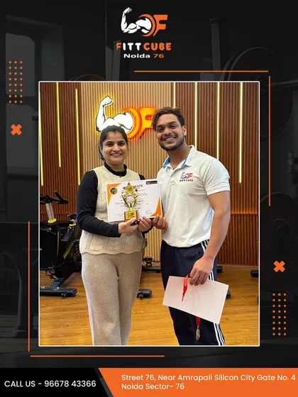We love celebrating our members' success. A client receives her certificate and a trophy from one of our trainers, recognizing her hard work and dedication.