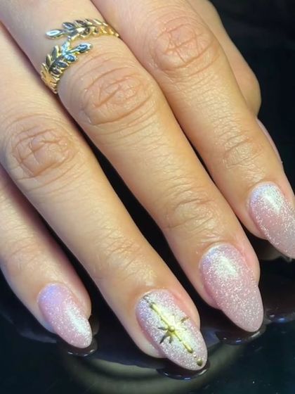 Another angle of the celestial-themed glitter nails, showing a delicate starburst design.
