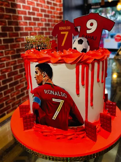 A Cristiano Ronaldo-themed cake for a football fan, featuring his jersey and an action shot, all in fiery red.