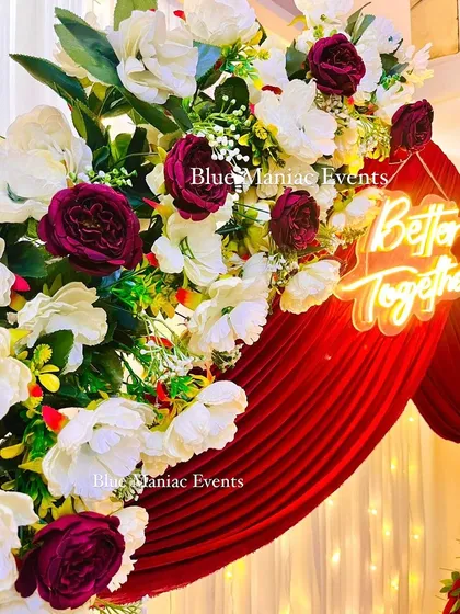 A detailed shot of the white and maroon florals with the 'Better Together' neon sign. This highlights the vibrant color combination and the quality of the artificial flowers used.