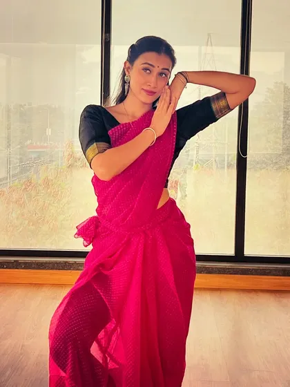 Expressing the feeling of a woman lost in thought, cherishing memories. This studio shot in a pink saree focuses on subtle facial expressions and body language to convey a specific emotion for narrative-driven concepts.