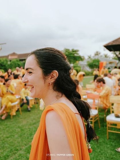 The bride, Eli, enjoying her Haldi ceremony. Her happy, natural smile shows she is completely immersed in the joyful celebration.