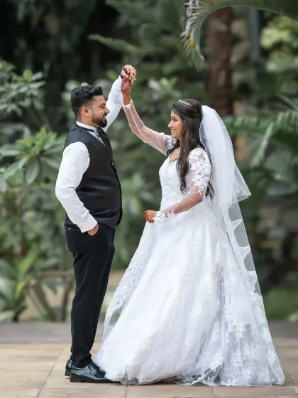 A playful dance move during the couple's portrait session. It’s a fun, dynamic shot that shows their happy and easygoing relationship.
