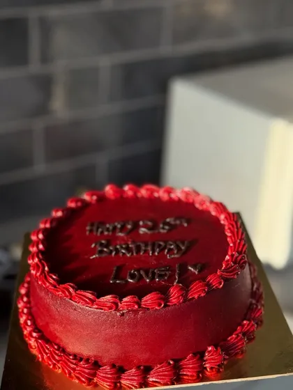 A rich, deep red cake with a personalized birthday message. The monochromatic design is bold, elegant, and makes a strong statement.
