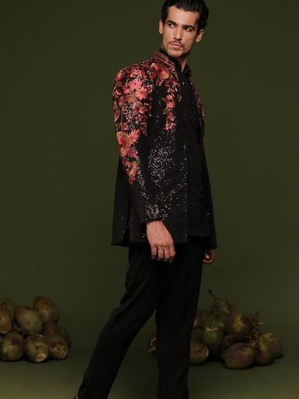 A professional model shot of the black floral Indo-Western suit, highlighting its modern silhouette and artistic embroidery.