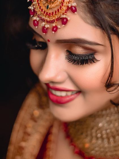 A beautiful close-up focusing on the bride's happy smile and stunning eye makeup. The dark background makes her features and jewellery pop. (Duplicate of 103)