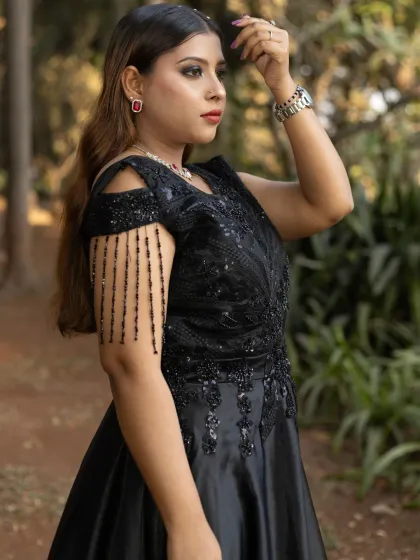 This black handwork gown with cold-shoulder details and hanging tassels is a perfect choice for a wedding guest or for a cocktail party.