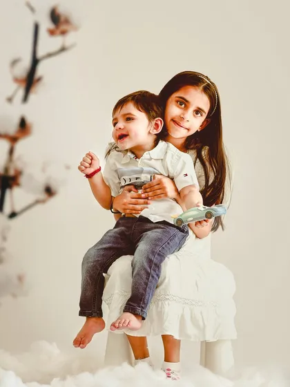 A candid moment between a big sister and her little brother. We create a comfortable space for siblings to interact naturally, capturing their true personalities.