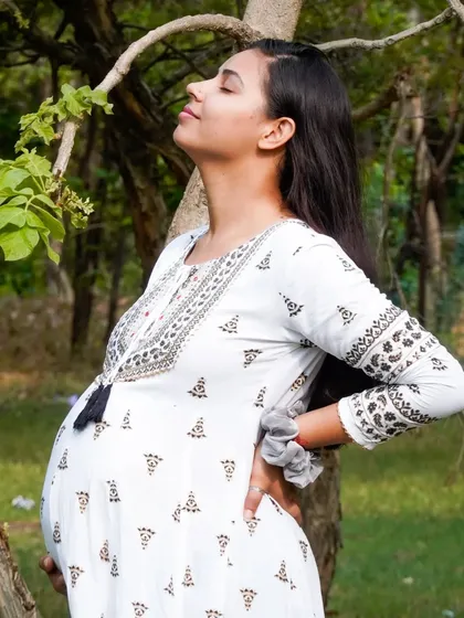 An expectant mother enjoying a moment of peace and sunshine during her outdoor maternity shoot. We aim to capture the glow of pregnancy.