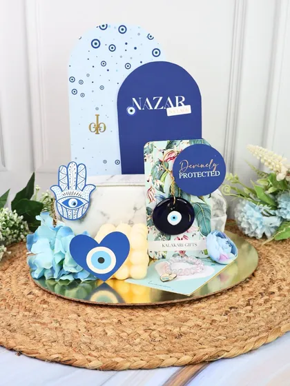 The Evil Eye Rakhi hamper displayed on a rustic jute mat, showing all the protective and stylish elements.