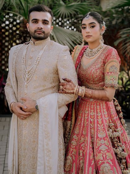 A classic and regal portrait of the couple. Their coordinated outfits and confident poses exude elegance and style.