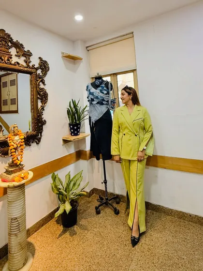 A photo from day one of my fashion styling workshop at the International College of Fashion. My lime green co-ord set with its creative construction stands next to a mannequin styled by one of the students.