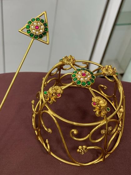 This gold-plated designer bun cover with green stones is a classic choice. The intricate design and high-quality materials make it a luxurious addition to your bridal look.