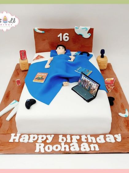 Level 16 unlocked! A cake depicting a teenager's ultimate chill zone: in bed with a laptop for Fortnite, a controller, and snacks.