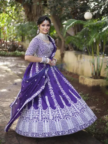 A full, smiling shot of the purple and white embroidered lehenga. The color is vibrant and the fit is designed to be both beautiful and comfortable.