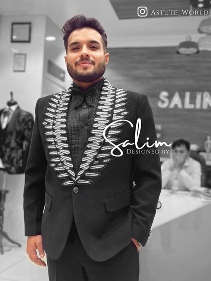 A mannequin displaying a black tuxedo with bold, feather-like silver embroidery on the lapels. The matching embellished shirt collar creates a fully integrated look.