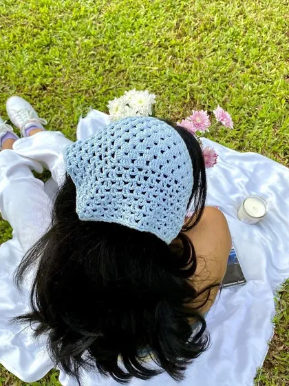 An overhead shot showing the detail of the crochet bandana. The open stitch pattern is delicate and stylish.