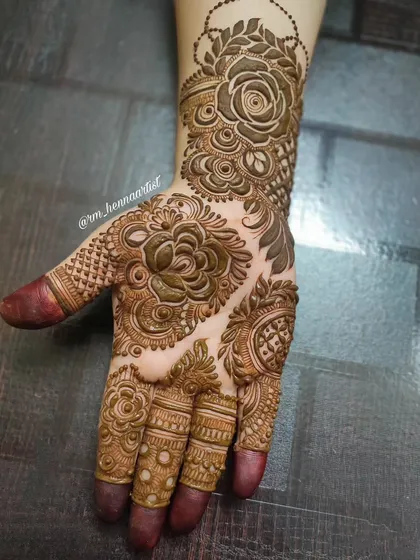 Creating this intricate floral mehendi for my sister-in-law was a joy. The design is filled with roses and leafy patterns that cover the hand completely.