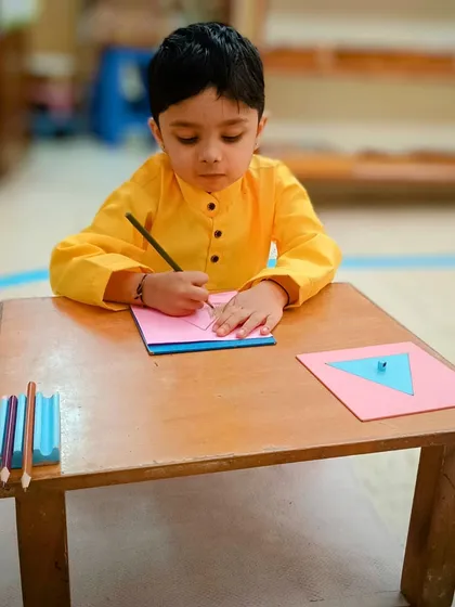 Look at the concentration. This child is working with geometric insets, an activity that indirectly prepares the hand for writing by strengthening the pincer grip and developing hand-eye coordination. This is how we build foundational skills naturally.