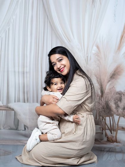A mother gives her baby a warm hug in this heartwarming portrait from their family session.