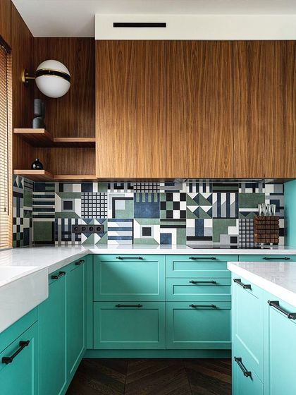Luxury redefined in a kitchen space. This design combines vibrant turquoise cabinets with a bold, patterned backsplash and rich wood tones, creating a unique and personalized look.