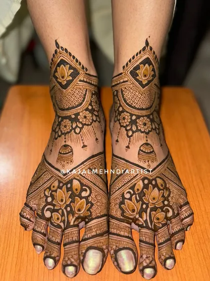 This design for bridal feet includes traditional jhumka (bell) motifs and lotus flowers, creating a festive and symmetrical look.