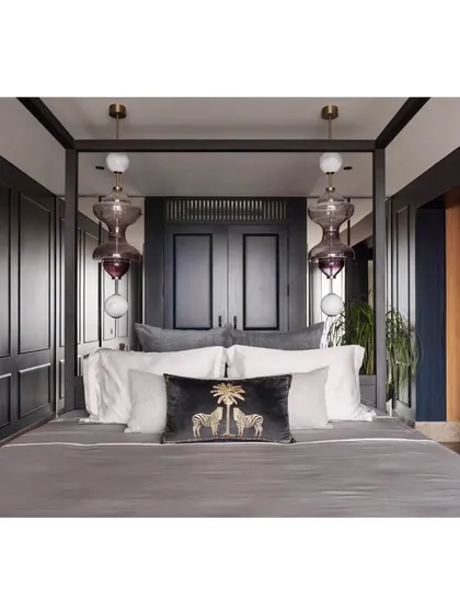 A master suite should be a sanctuary. For this high-rise apartment, we created a moody and luxurious retreat with a custom four-poster bed, deep blue paneling, and exquisite blown-glass pendant lights. The design balances opulence with personal comfort, creating a space that feels like a private escape from the city below.