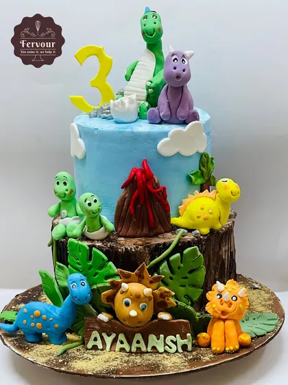 A dinosaur-themed cake perfect for a little explorer's 3rd birthday. This design features a whole world of hand-crafted fondant dinosaurs, a volcano, and jungle details on a delicious chocolate cake base.