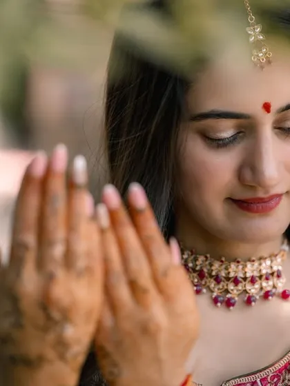 A close-up, artistic shot of the bride looking at her hands, with soft focus creating a dreamy effect.
