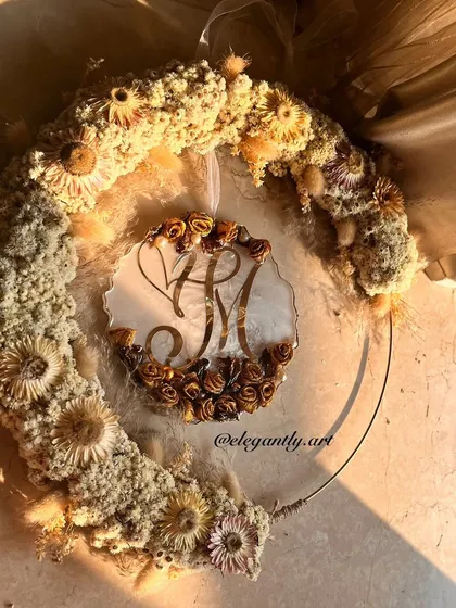 The golden hour light on this hanging logo wreath is just magical. The preserved flowers and custom logo create a stunning piece of art that celebrates love.