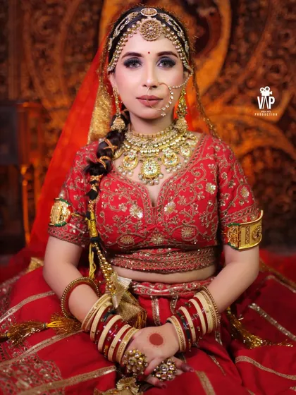 A full seated portrait of a bride in our complete Rajwada jewellery set. This look includes a heavy choker and layered necklace, an elaborate matha patti, a traditional nath, and matching hand jewellery.