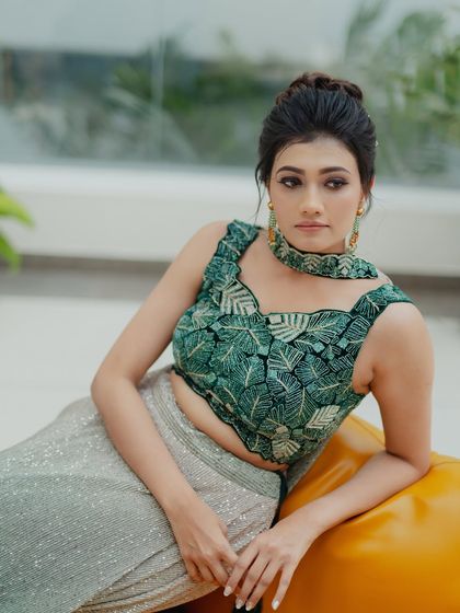 A chic and modern pose, highlighting the unique design of the outfit and the sophisticated makeup and hairstyle.