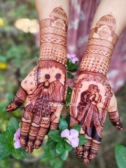 Another angle of the beautifully stained story mehndi, set against a floral background. The rich color highlights the intricate details of the couple's portrait.