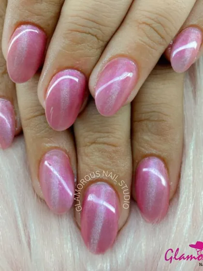 A simple and elegant manicure featuring a shimmery, pearlescent pink polish with a subtle cat-eye effect.
