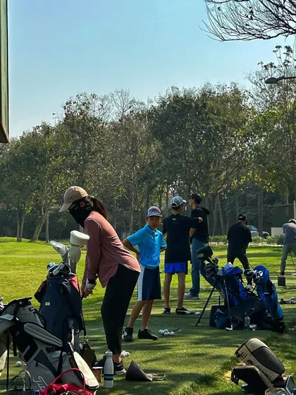 A group of young golfers and a female player get their practice in, showing the diversity of our community.