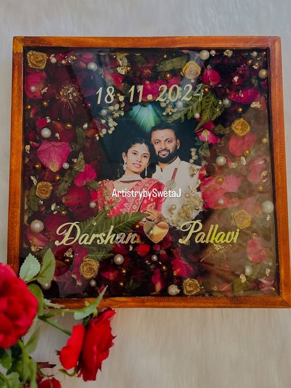 A full view of this heartfelt wedding keepsake. The deep red of the preserved roses contrasts beautifully with the wooden frame, creating a rich and timeless piece of art for the couple's home.
